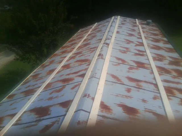 Rusted metal roof panels with new wood purlins before replacement — Storm Damage Roof Repair in Belvidere by Roofing Brothers