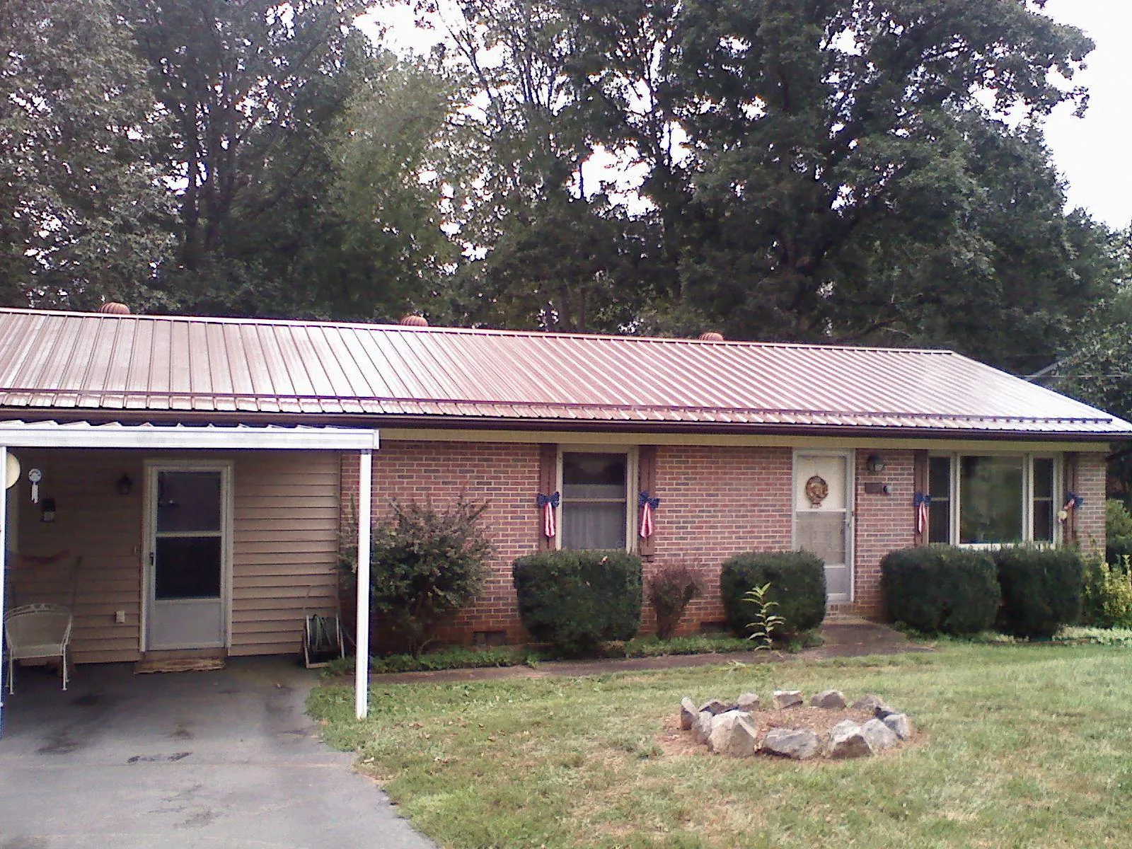 Bronze metal roof and carport on a brick ranch home — Roof Repair work by our crew in Belvidere